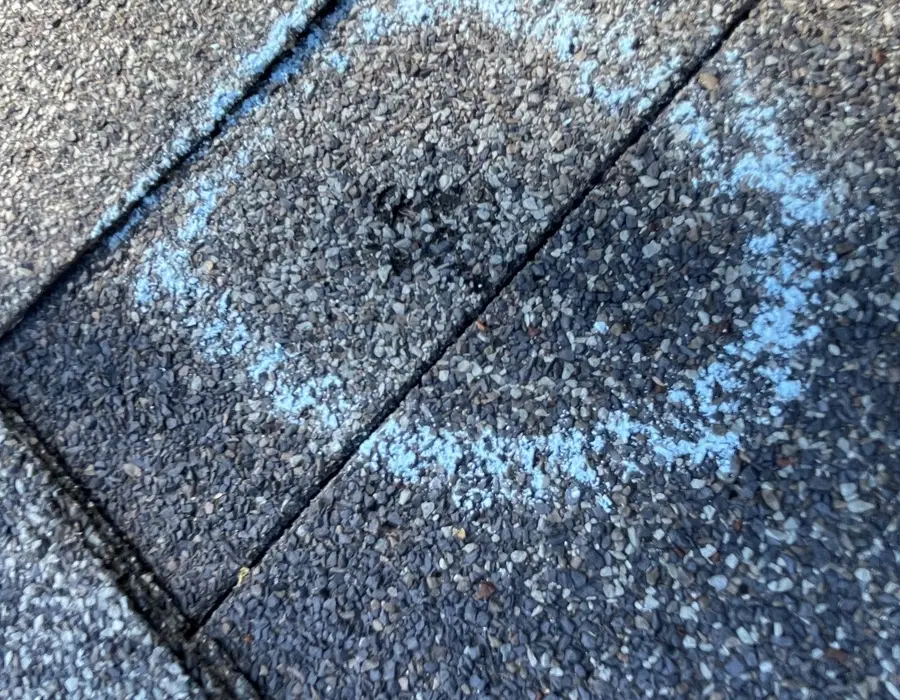 Hail hit on a shingle, chalk-circled during an inspection