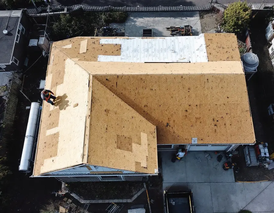 Mid-century rambler stripped to bare decking, every sheet checked before the new roof