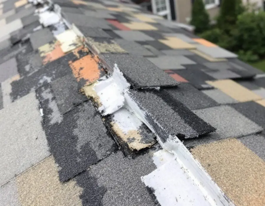 A roof patched past the point of sense: mismatched shingles and tar smears