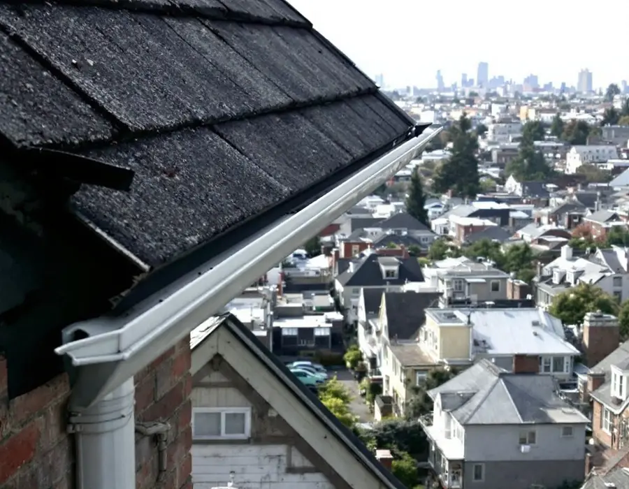 Looking over the eave and gutter across an old city neighborhood