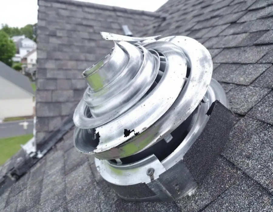 Metal roof vent cap bent by hail