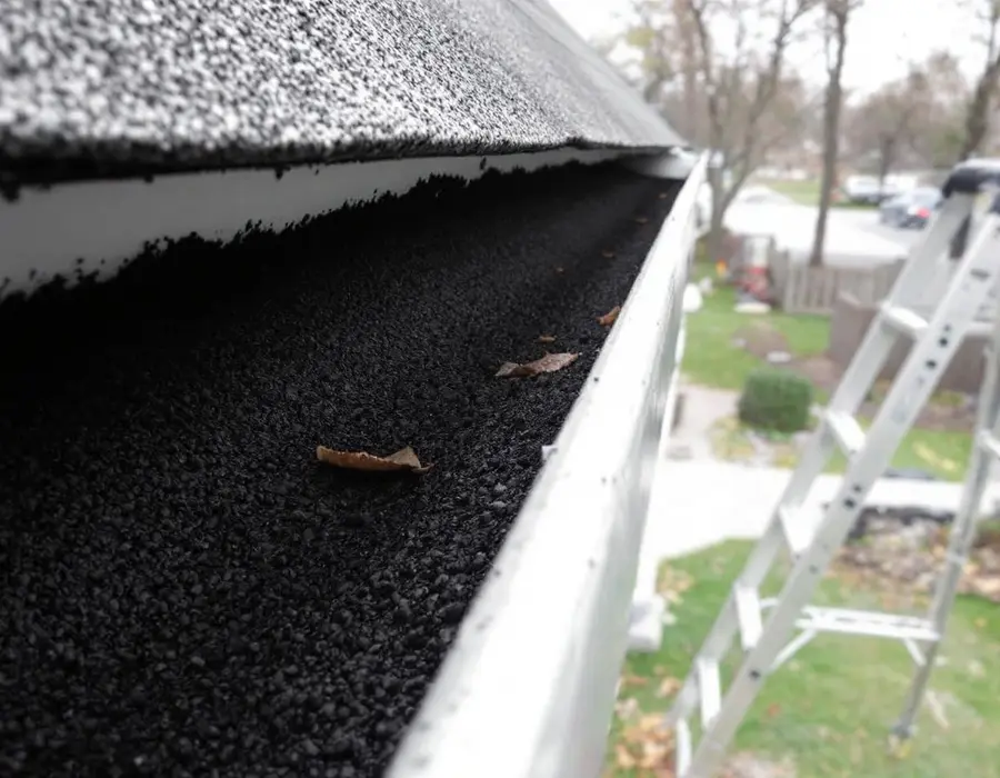Rain gutter lined with shingle granules after a hailstorm